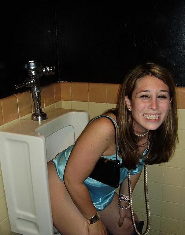 Girl using a urinal nude